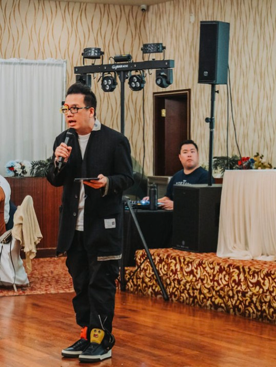 Foksifu on the microphone with his DJ setup and lighting at a San Jose wedding reception